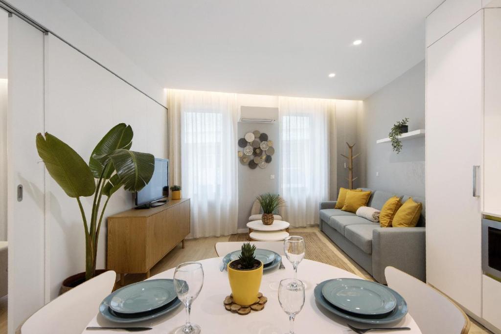 ein Wohnzimmer mit Tisch und Stühlen und einer Couch in der Unterkunft T1 Moliceiros Centro de Aveiro in Aveiro