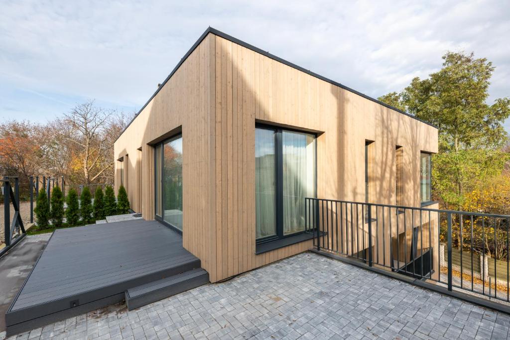 une maison avec des portes vitrées et un balcon dans l'établissement Cottage Luxe Žaliakalnis, à Kaunas