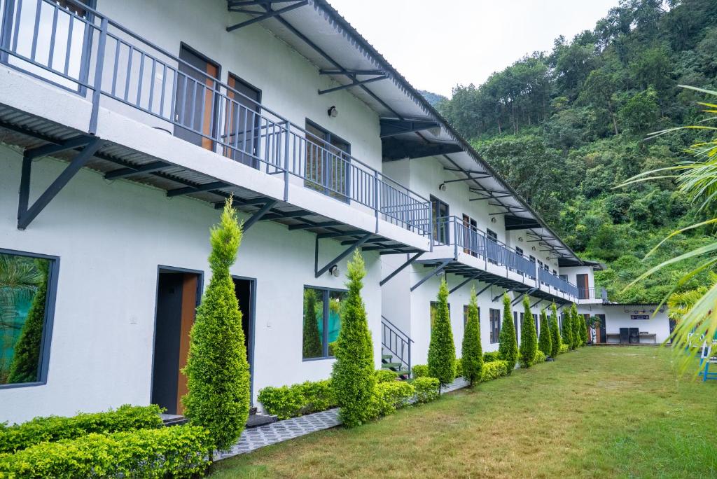 een rij witte gebouwen met groene planten bij Qcent Bairagarh Resort Rishikesh in Mohan Chatti
