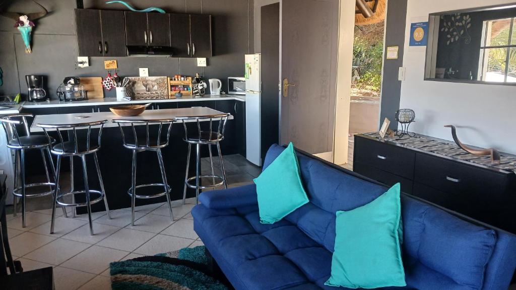 uma sala de estar com um sofá azul e uma cozinha em John-Lou's Studio Flat em Windhoek