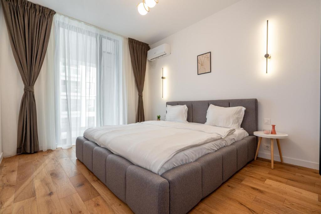 Central ONE Comfort plus Parking في بوخارست: سرير كبير في غرفة مع نافذة كبيرة
