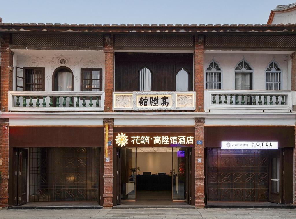 a brick building with two balconies on top of it at Floral Hotel Gaosheng in Zhangzhou