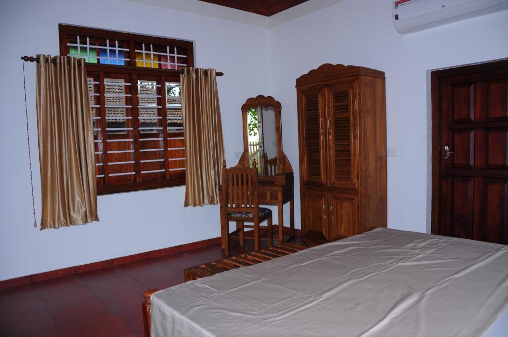 Postel nebo postele na pokoji v ubytování Alleppey Beach Garden
