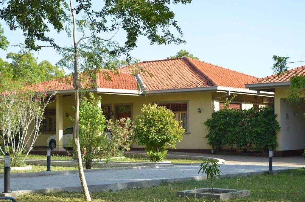 une maison jaune avec un toit orange dans l'établissement Lake View Bungalow Yala, à Tissamaharama