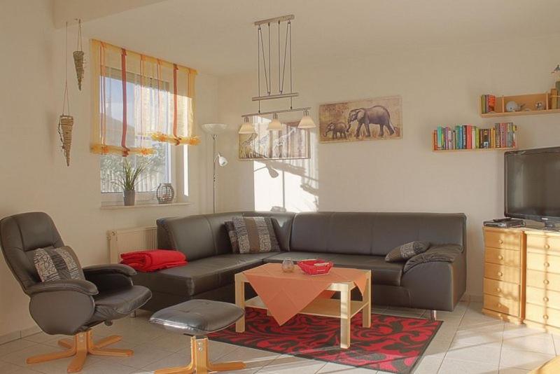 a living room with a couch and two chairs and a table at Achteckhaus Moritz LT35 in Dorum Neufeld