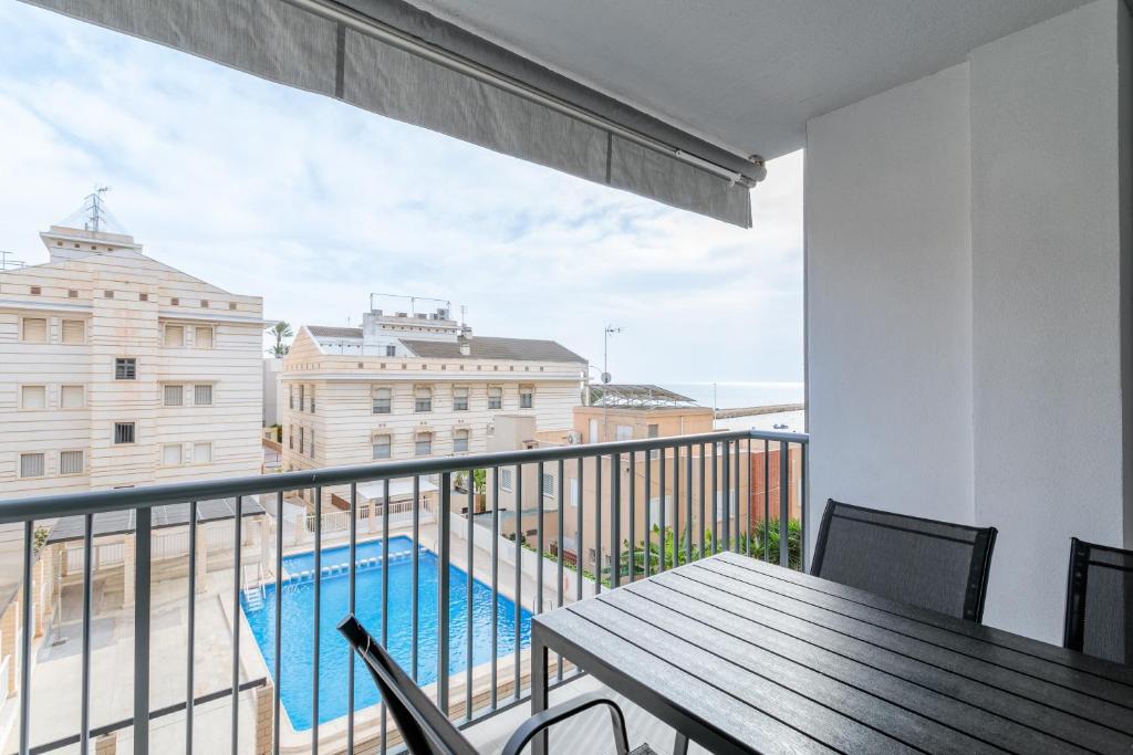 a balcony with a table and a swimming pool at Mar 4 en Santa Pola in Santa Pola