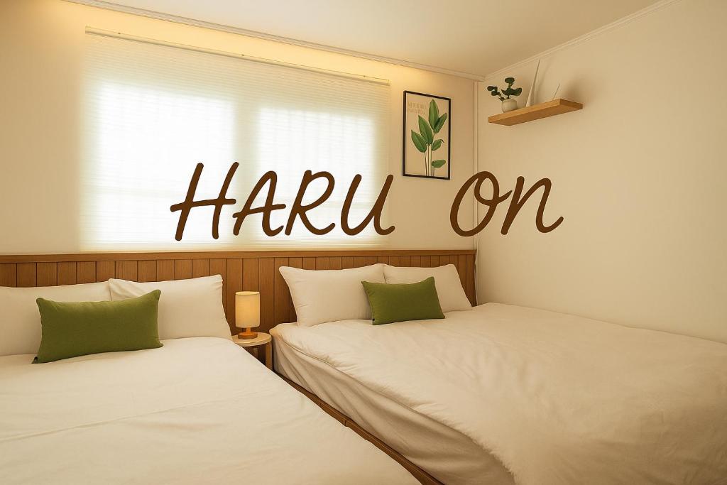 Dos camas en una habitación con un cartel de agradecimiento en la pared. en new 하루 온 올리모델링 청결중시 잠실 롯데월드 올림픽공원 성수 강남, en Seúl