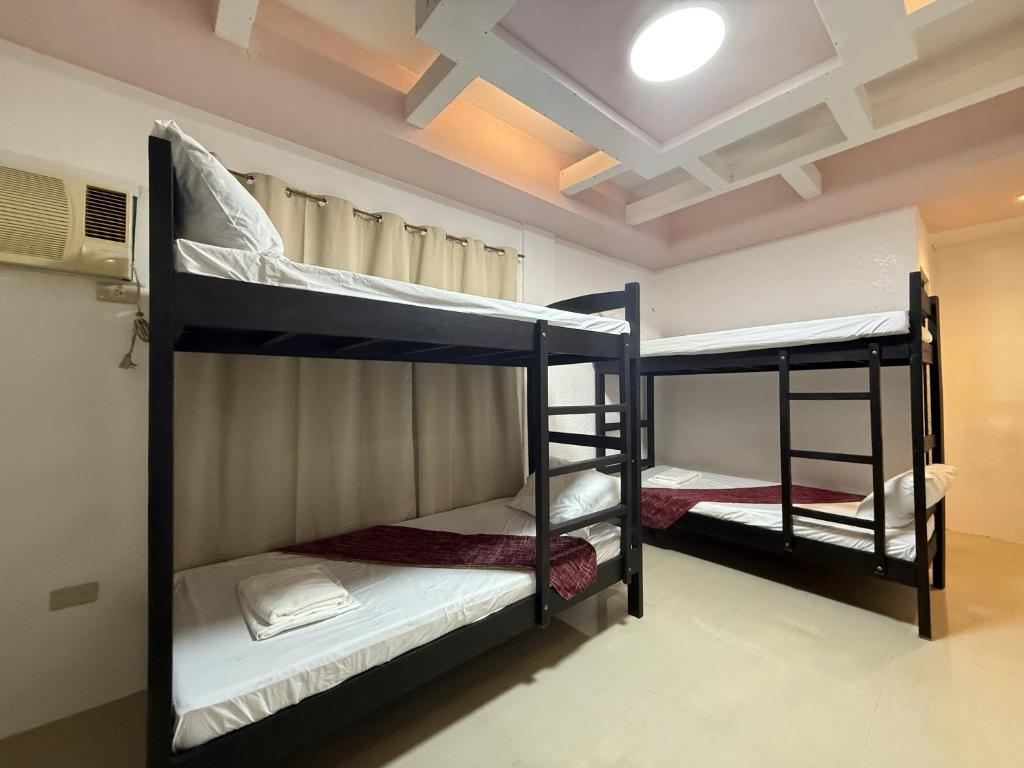 2 letti a castello in una camera con soffitto di Cozy Stop Inn - Puerto Princesa a Città di Puerto Princesa