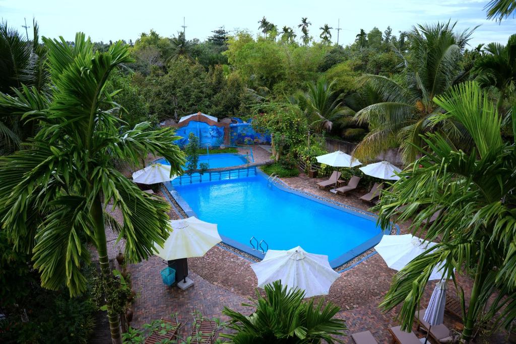 an overhead view of a swimming pool with umbrellas at Vamxang Rustic Home in Can Tho