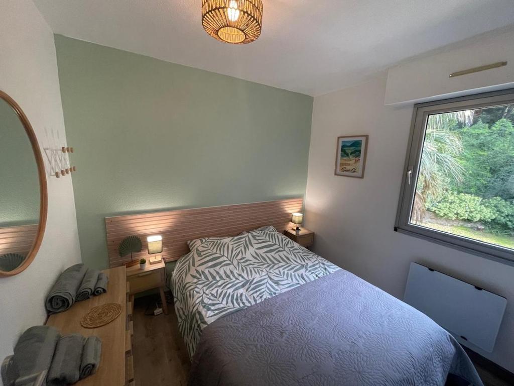 ein Schlafzimmer mit Bett, Schreibtisch und Fenster in der Unterkunft Azur Bay Boho-Chic T2 Garage & Mer Pet-Friendly in La Ciotat