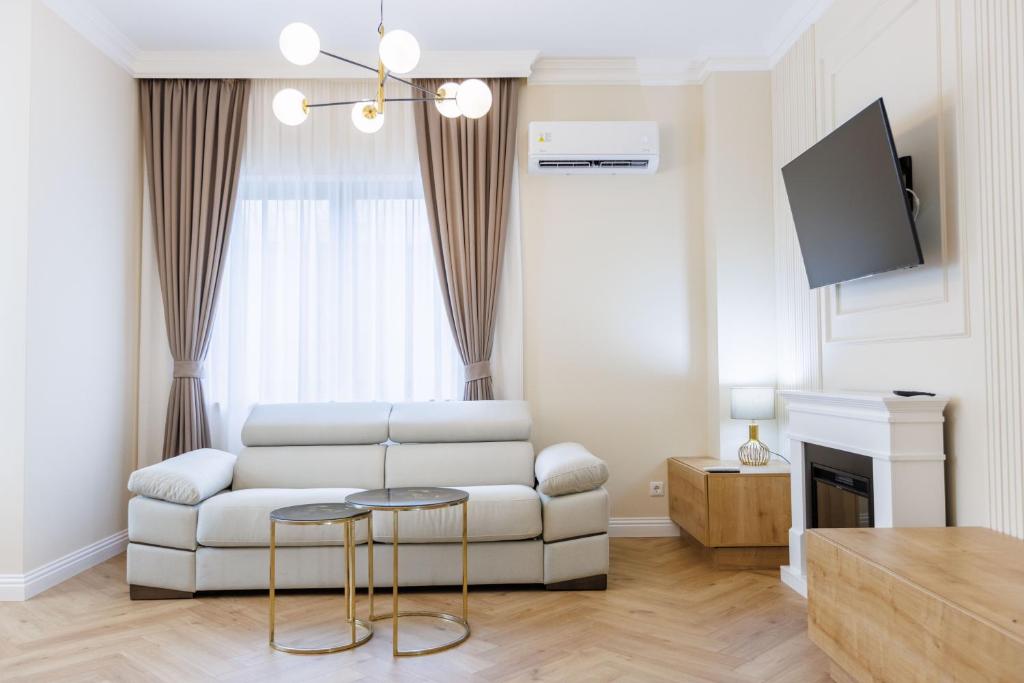 a living room with a white couch and a tv at ApartButterfly in Baia Mare