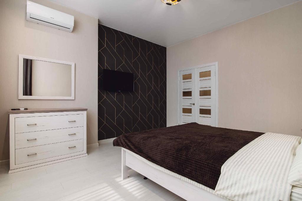 ein Schlafzimmer mit einem Bett und einer Kommode in der Unterkunft К МОРЮ 5 мин! Французский бульвар 26 спальных мест 6 ! in Odessa