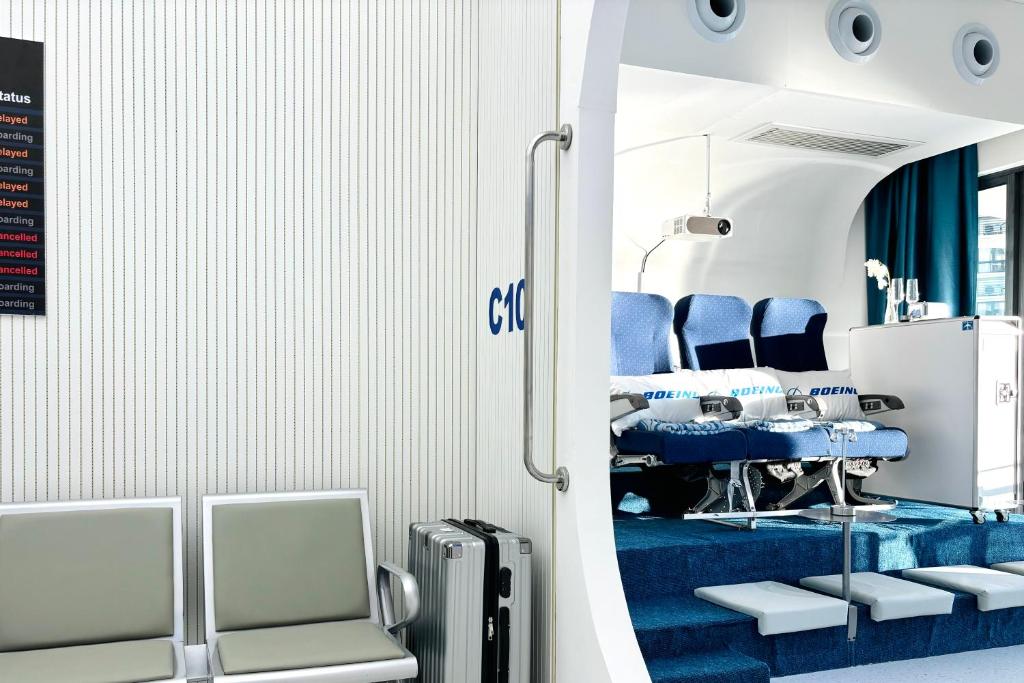 un salon avec des chaises bleues, une table et une valise dans l'établissement Country Garden Fully Unblocked Seaview Suite by Dooga's Homestay, à Johor Bahru