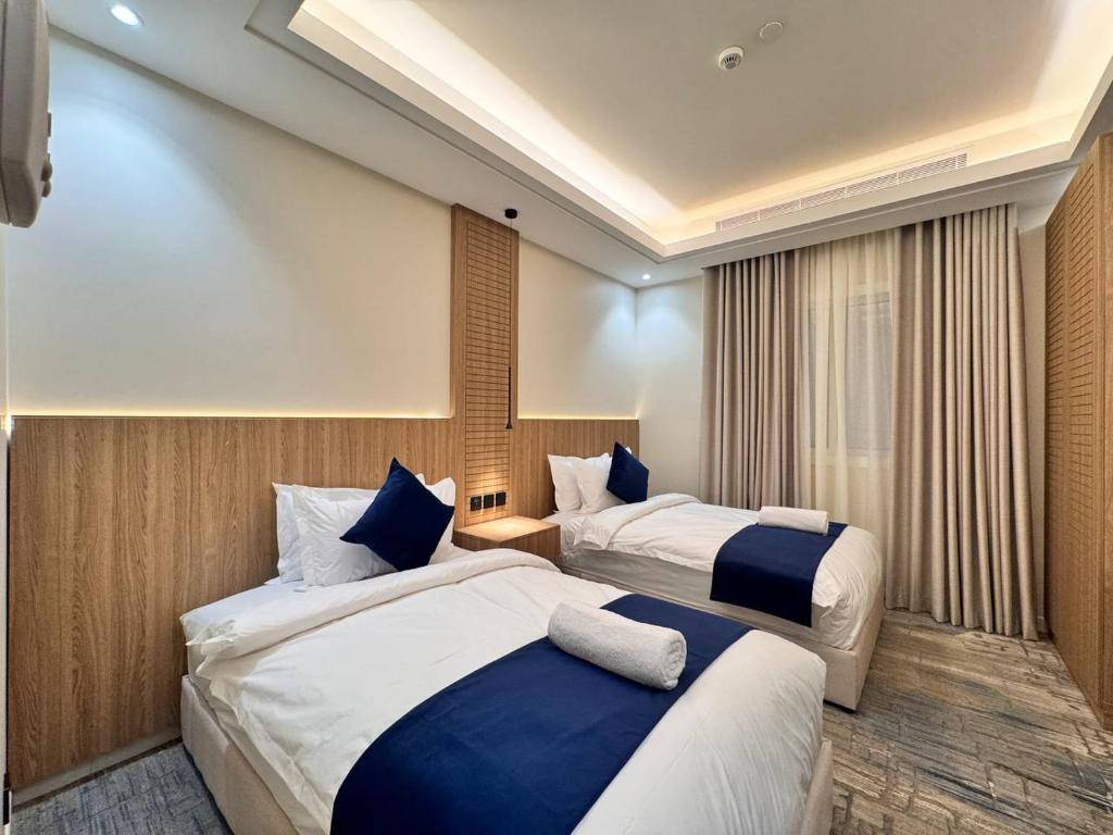 a hotel room with two beds with blue pillows at فندق ارجان بارك جدة in Jeddah