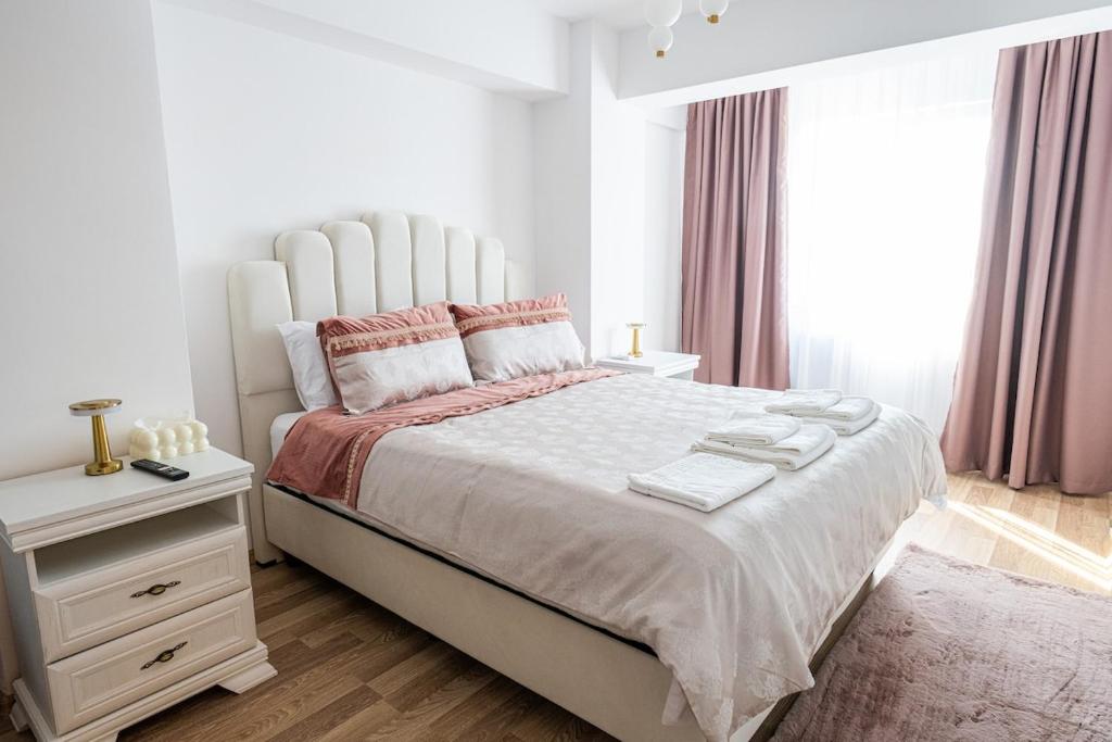 een witte slaapkamer met een groot bed en een nachtkastje bij Apartament de închiriat Accommodation Ap 9 in Suceava