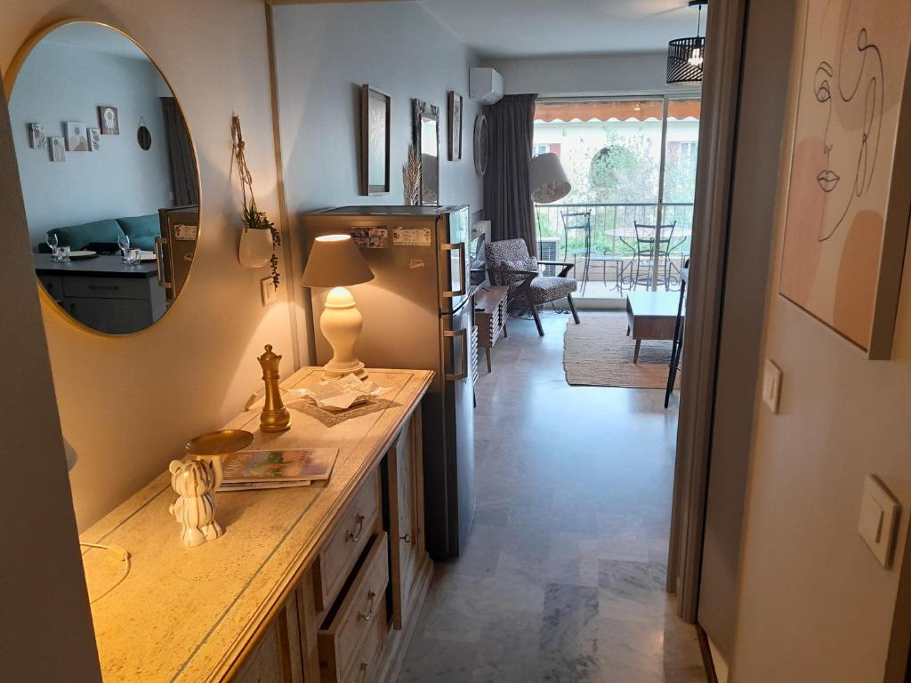 a kitchen with a table with a lamp and a mirror at Appartement à 100m de la plage in Mandelieu-la-Napoule