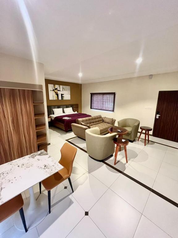 ein großes Wohnzimmer mit einem Sofa und Stühlen in der Unterkunft Elegant Studio Haven Offering Peace, Comfort & Style in Mama