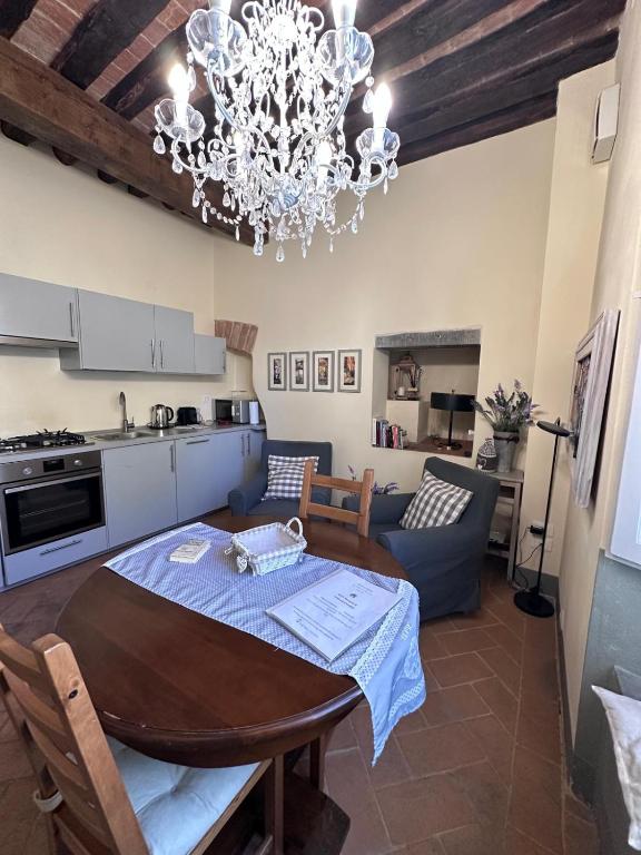 a kitchen and living room with a table and a chandelier at Casina Bella in Cortona
