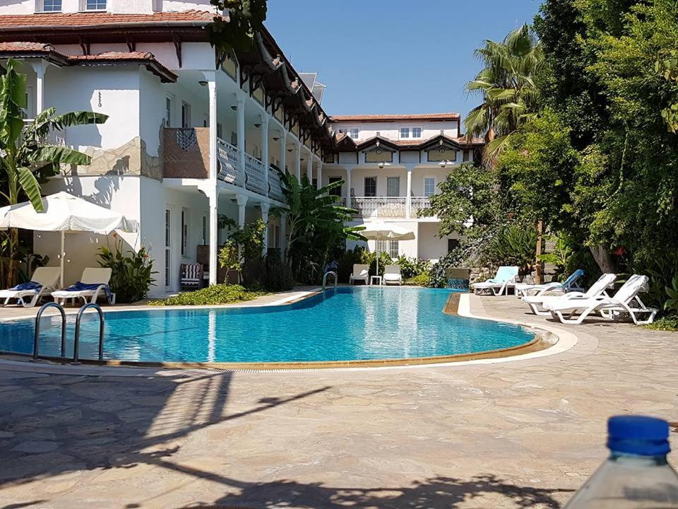 a hotel with a swimming pool in front of a building at Central Park Otel - Adult Only in Dalyan