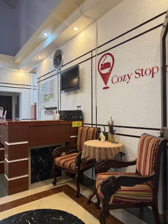ein Café mit Tisch, Stühlen und einer Theke in der Unterkunft Cozy Stop Inn - Puerto Princesa in Puerto Princesa