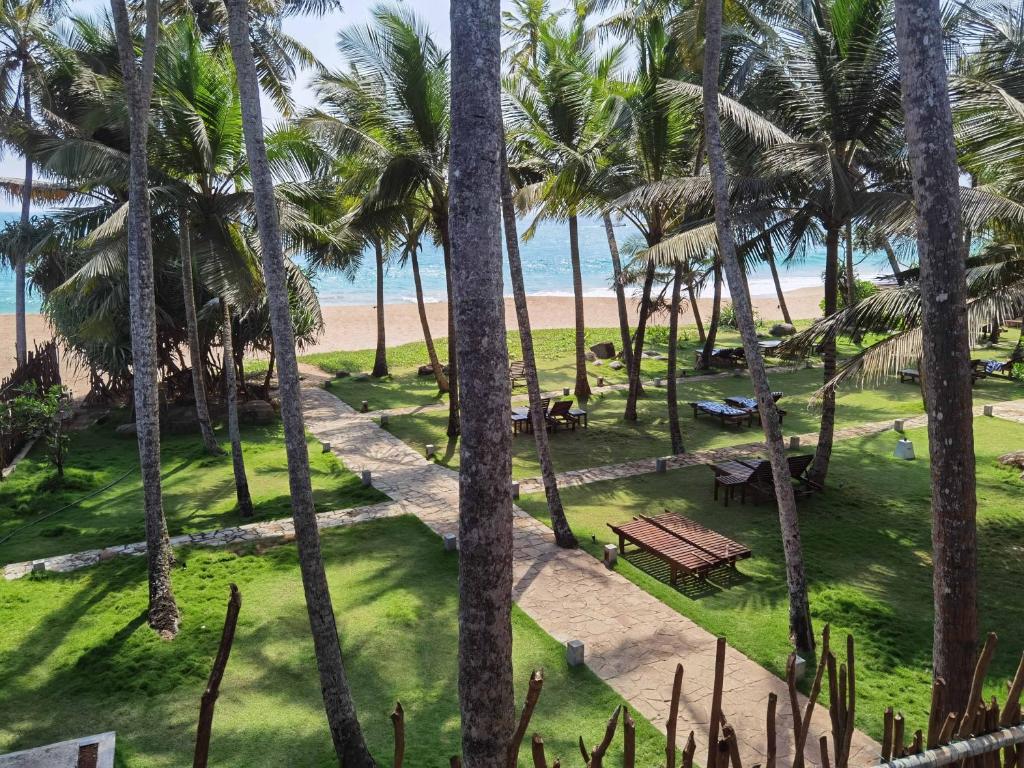 an aerial view of a park with palm trees and a beach at Kiyoko Villa in Maha Induruwa