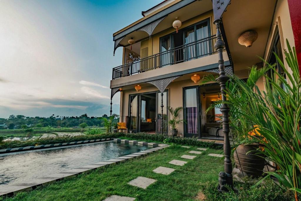 a villa with a swimming pool in front of a house at Theatrical 4bd Villa Escapades with epic Rice Terraces Panoramas in Cemagi