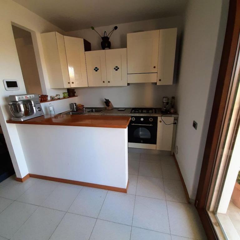 een kleine keuken met witte kasten en een fornuis bij La casa sul lago dorato in Magione