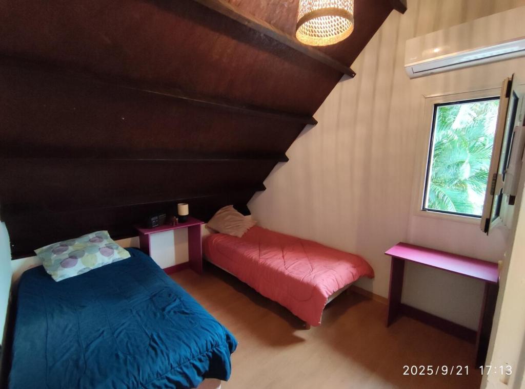 Schlafzimmer mit einem Bett und einer roten Bank in der Unterkunft Ô Chalet in Saint-Philippe