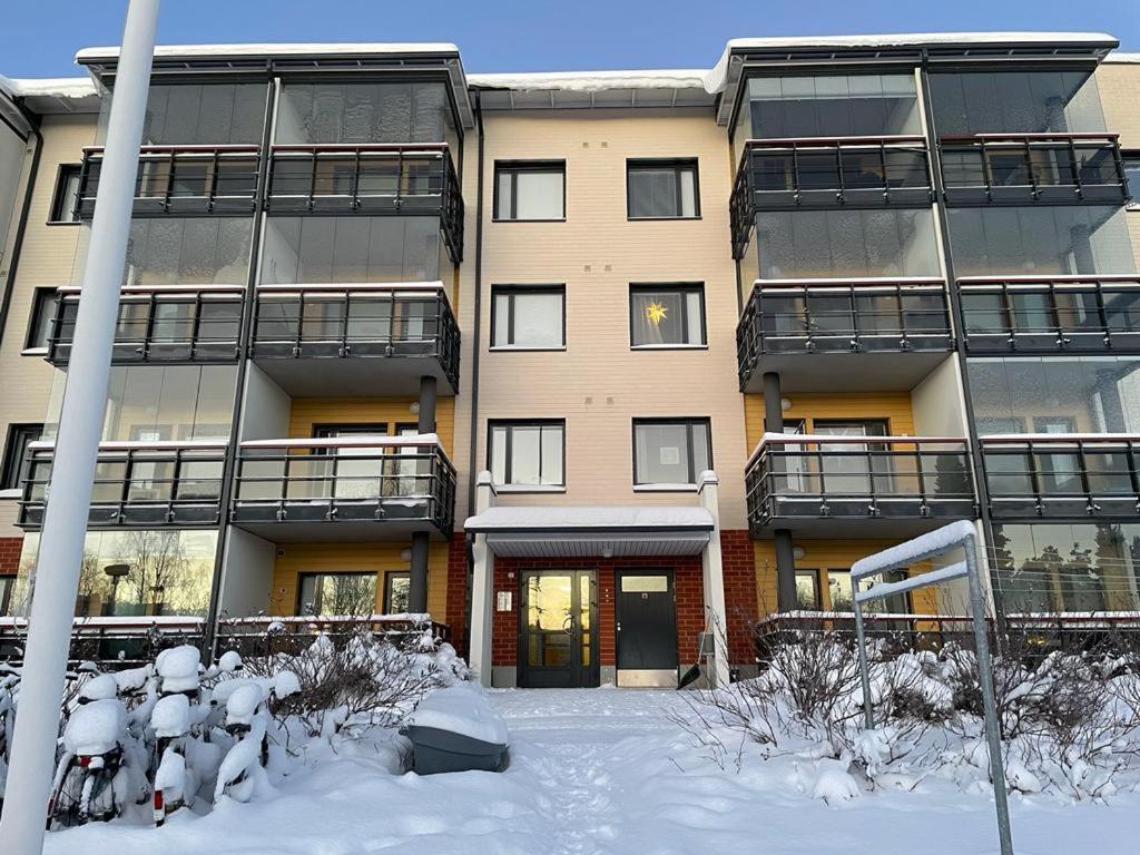un immeuble d'appartements avec de la neige devant lui dans l'établissement Cozy apartment with sauna, à Rovaniemi