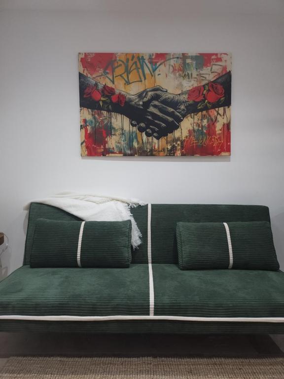 ein grünes Sofa in einem Zimmer mit einem Gemälde an der Wand in der Unterkunft Duplex design in Vedène