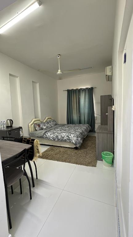 um quarto com uma cama e uma secretária em Near Airport Rooms em Mawāliḩ