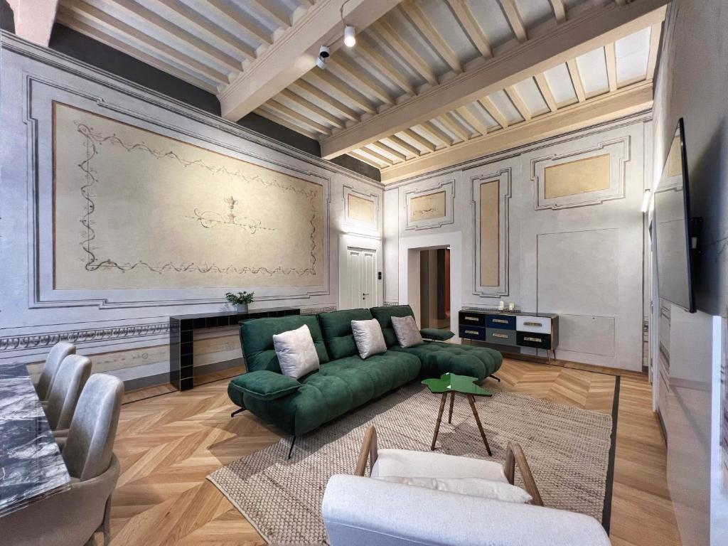 a living room with a green couch and a painting on the wall at Residenza DuLà in Arezzo