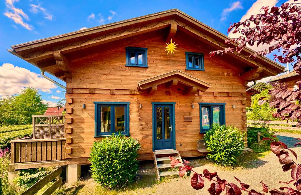 a log cabin with a star on the roof at Harz-Blockhaus, 4 und 5 Sterne, Sauna - und Kamin - KH in Hahnenklee-Bockswiese