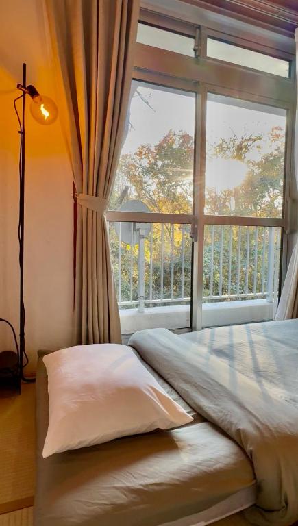 a bed in a room with a large window at FUJI Forest House103 in Gotemba
