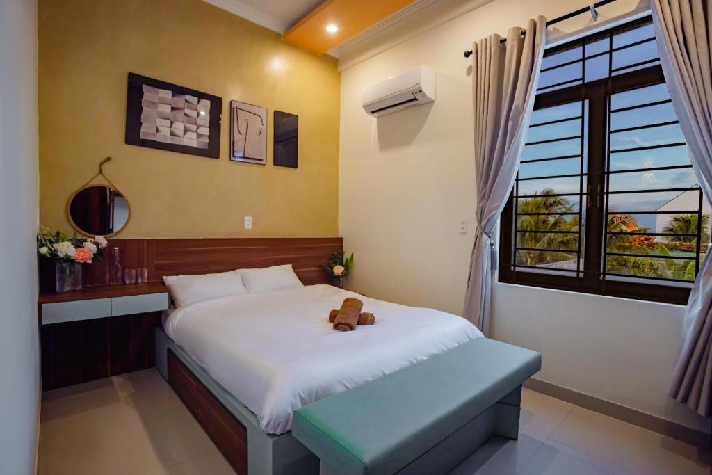 Un dormitorio con una cama con un osito de peluche encima. en Villa De Doc Let Homestay, en Nha Trang