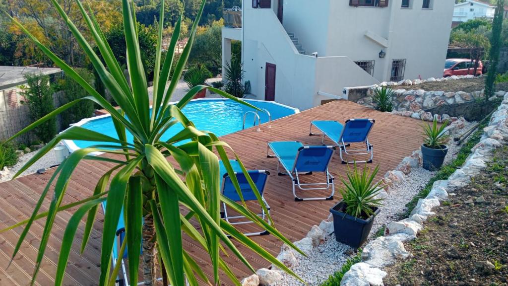 een terras met stoelen en een zwembad bij Richmond Villa Greece in Póros