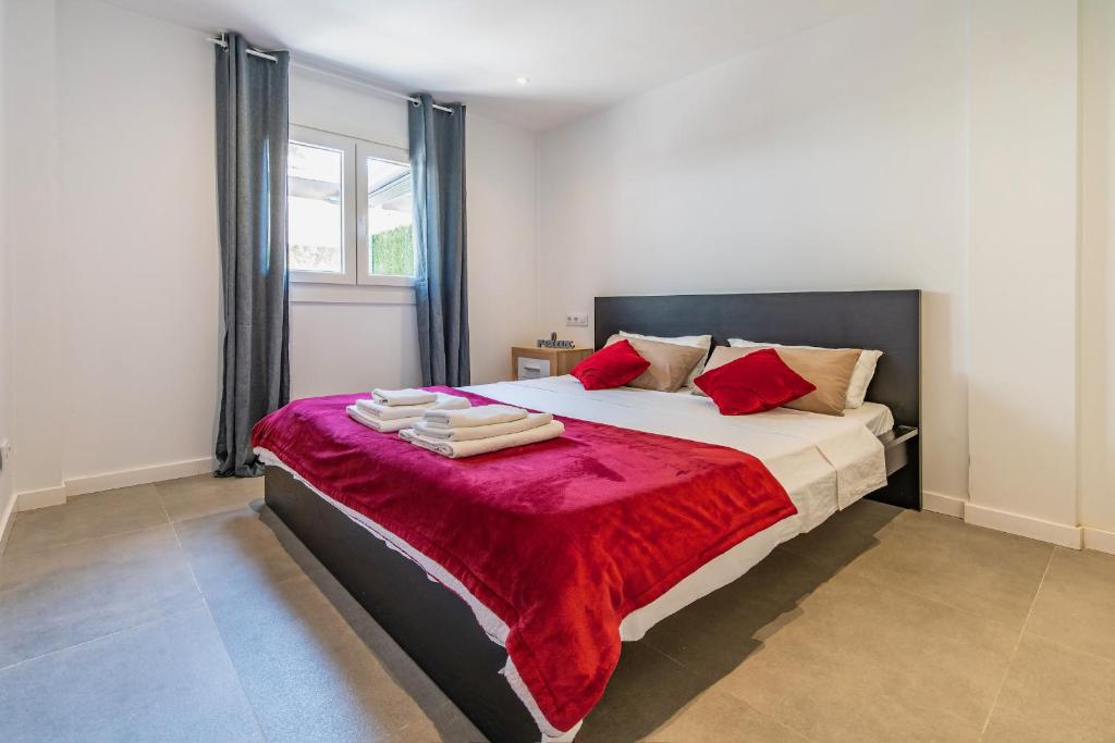 Apartamento Cabrera by Mallorca Infinity في باغيرا: غرفة نوم بها سرير كبير وبطانية حمراء
