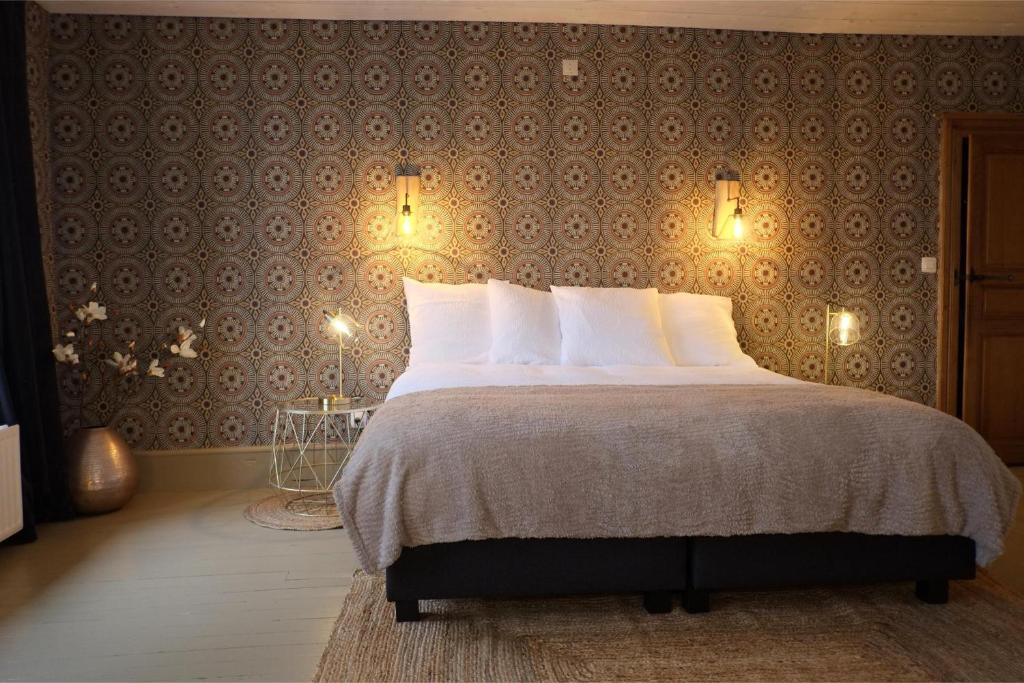 a bedroom with a large bed with a wall at Au Petit Bercail - 2 Chambres d'hôtes pour 2 personnes in Chiny