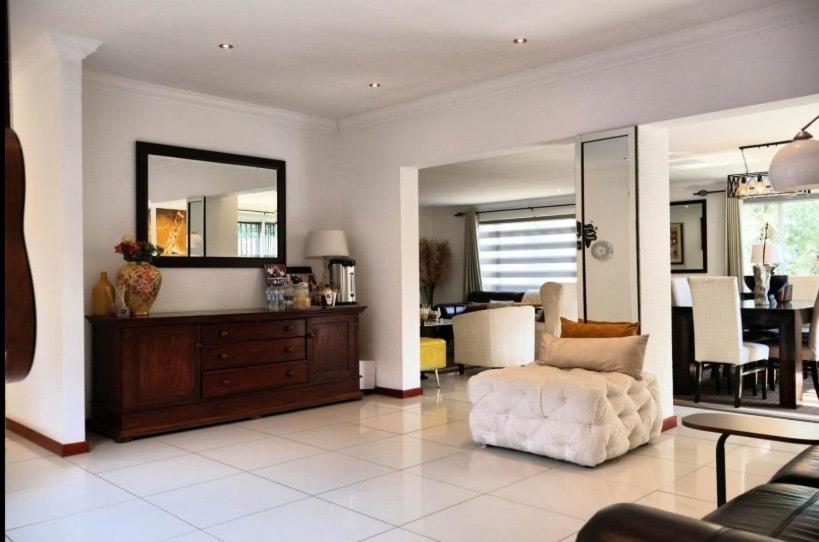 a living room with a couch and a mirror at The Condor Nest! in Sandton