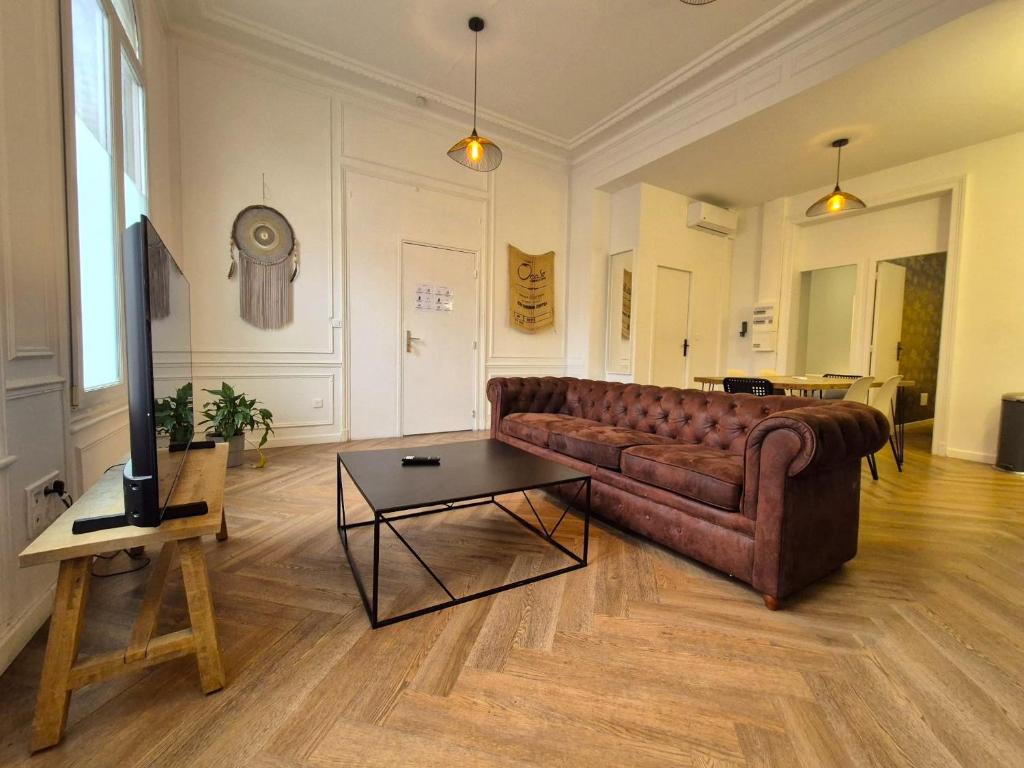 ein Wohnzimmer mit Sofa und Tisch in der Unterkunft Bogota - Charme central à Reims - 6P in Reims