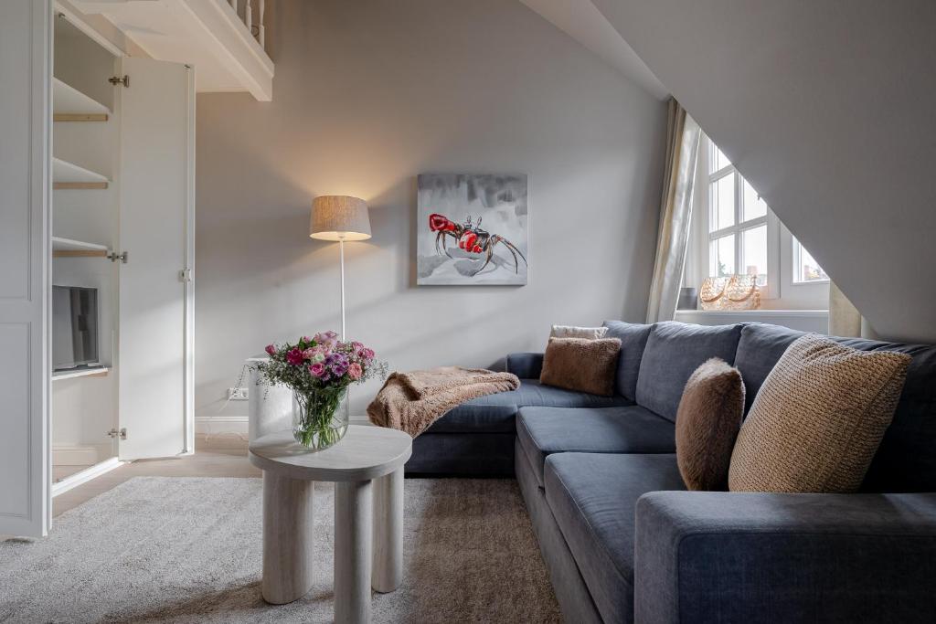 a living room with a blue couch and a table at Leo in Keitum