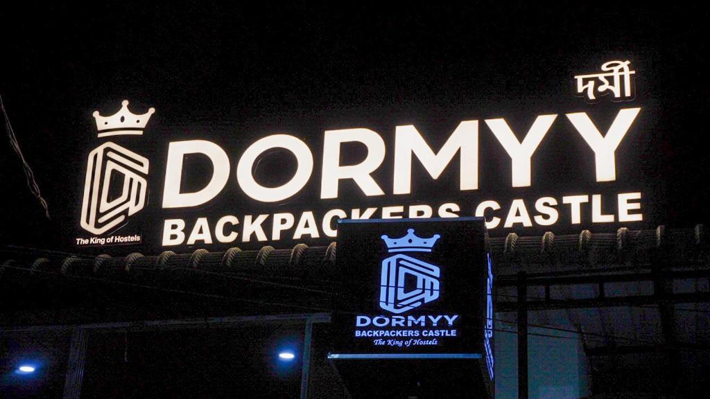 a sign for a denny backyards castle at night at Dormyy backpackers castle in Guwahati