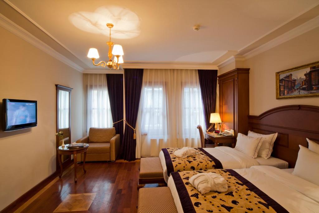 a hotel room with two beds and a chair at GLK PREMIER The Home Suites & Spa in Istanbul