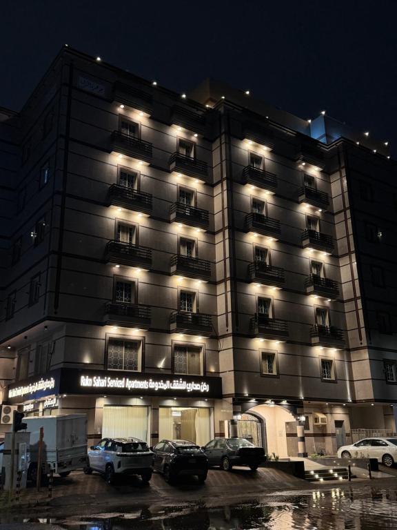 ein Gebäude mit nachts auf einem Parkplatz geparkt in der Unterkunft ركن صحاري للشقق المخدومة 6 جدة Rukn Sahari For Served Apartments in Quai