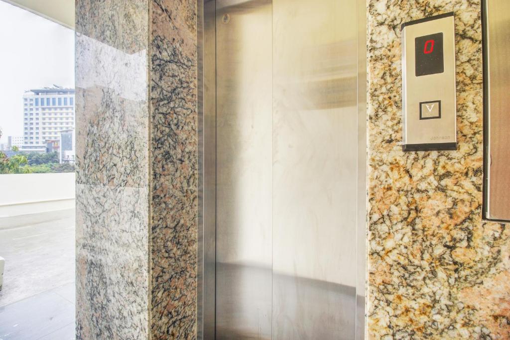 einen Aufzug in einem Gebäude mit einer Steinmauer in der Unterkunft Super Hotel O EMBASSYINN in Kondapur