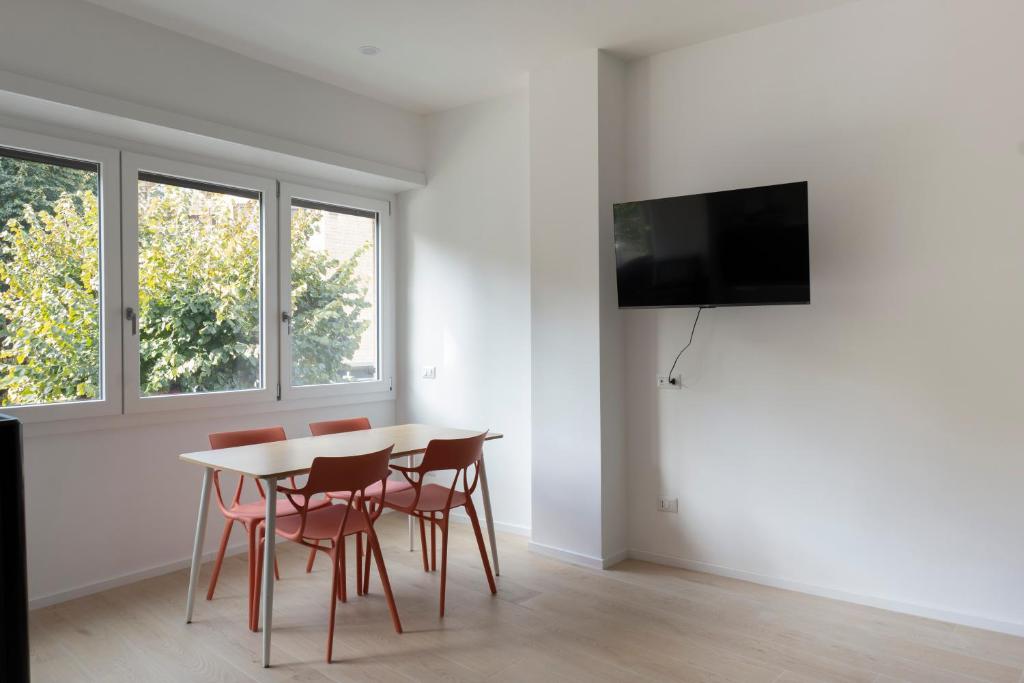 Un comedor con mesa y sillas y un televisor. en EUR Suites, en Roma