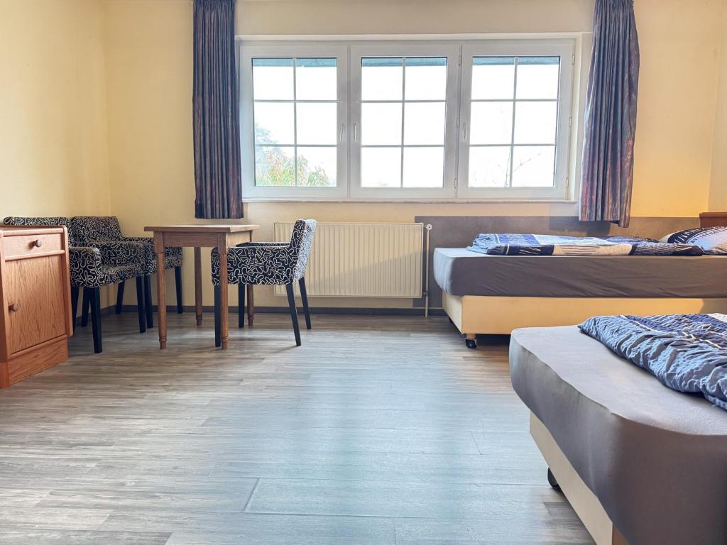 a room with two beds and a table and chairs at 33 - 12 Hotelkamer voor twee personen in Bunkenburg