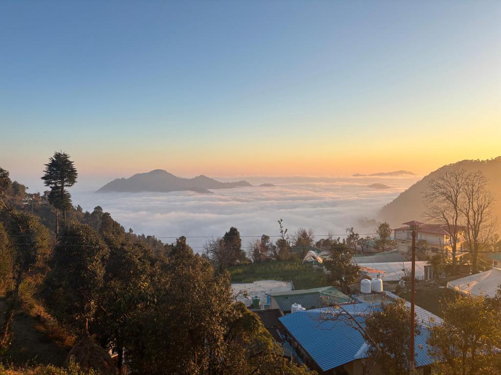 a view of a foggy valley with mountains in the background at Hotel Goludev Valley View in Nainital