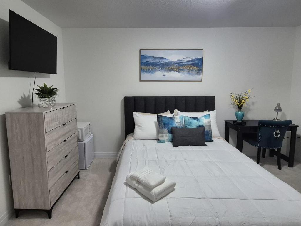 a bedroom with a large white bed and a desk at First Class Ensuite Room in Brantford