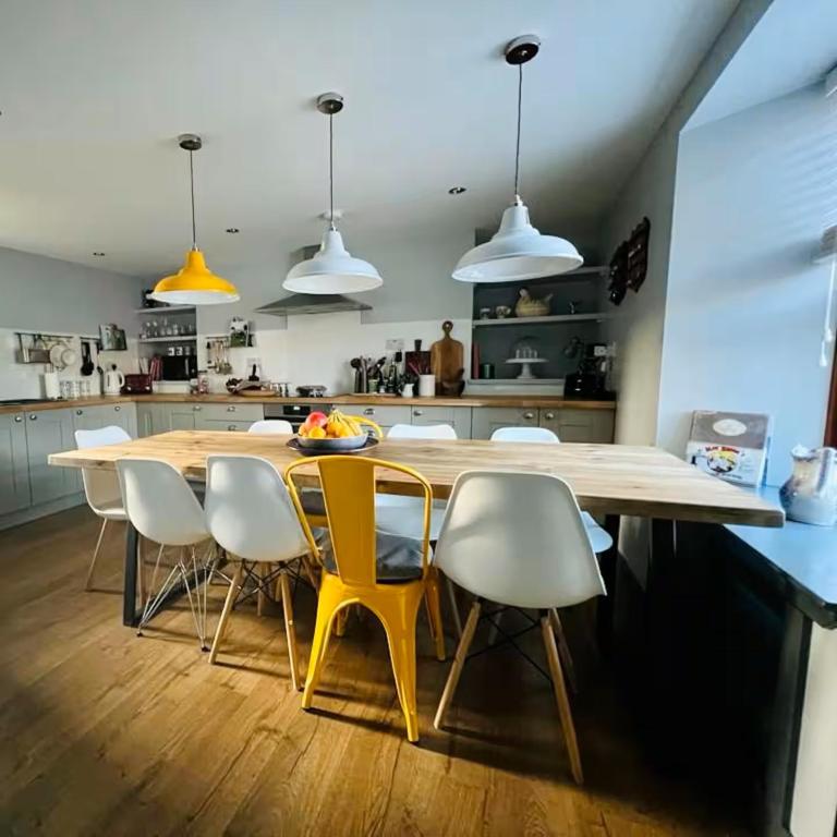 a kitchen with a wooden table and chairs at Aald Harbour Hoose, Shetland Islands in Lerwick